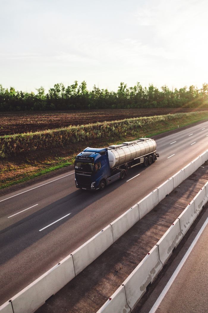 Services A tanker truck traveling on a highway in Russia during sunset, capturing the essence of transportation.