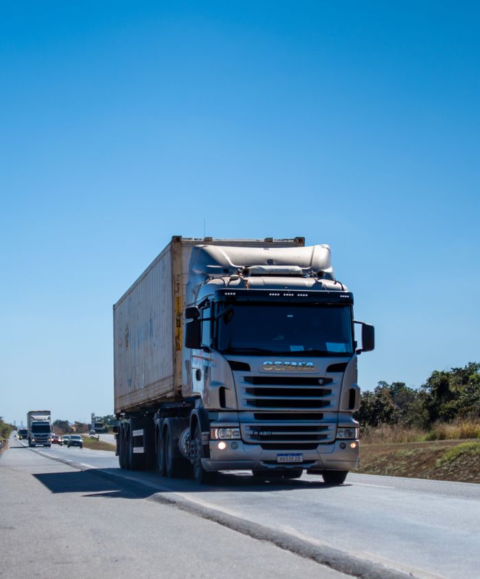 Home A large cargo truck travels on a highway in Brazil under clear blue skies.